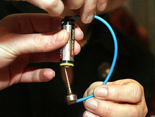 Can you make the world’s simplest motor? It’s a simple as putting a screw on a small, strong, cylindrical magnet and letting the top of the screw (the sharp end) attach itself magnetically to the bottom of a battery. Now use a piece of wire to connect the upper pole of the battery with the side of the magnet and ‘Hey Presto’: the motor spins!